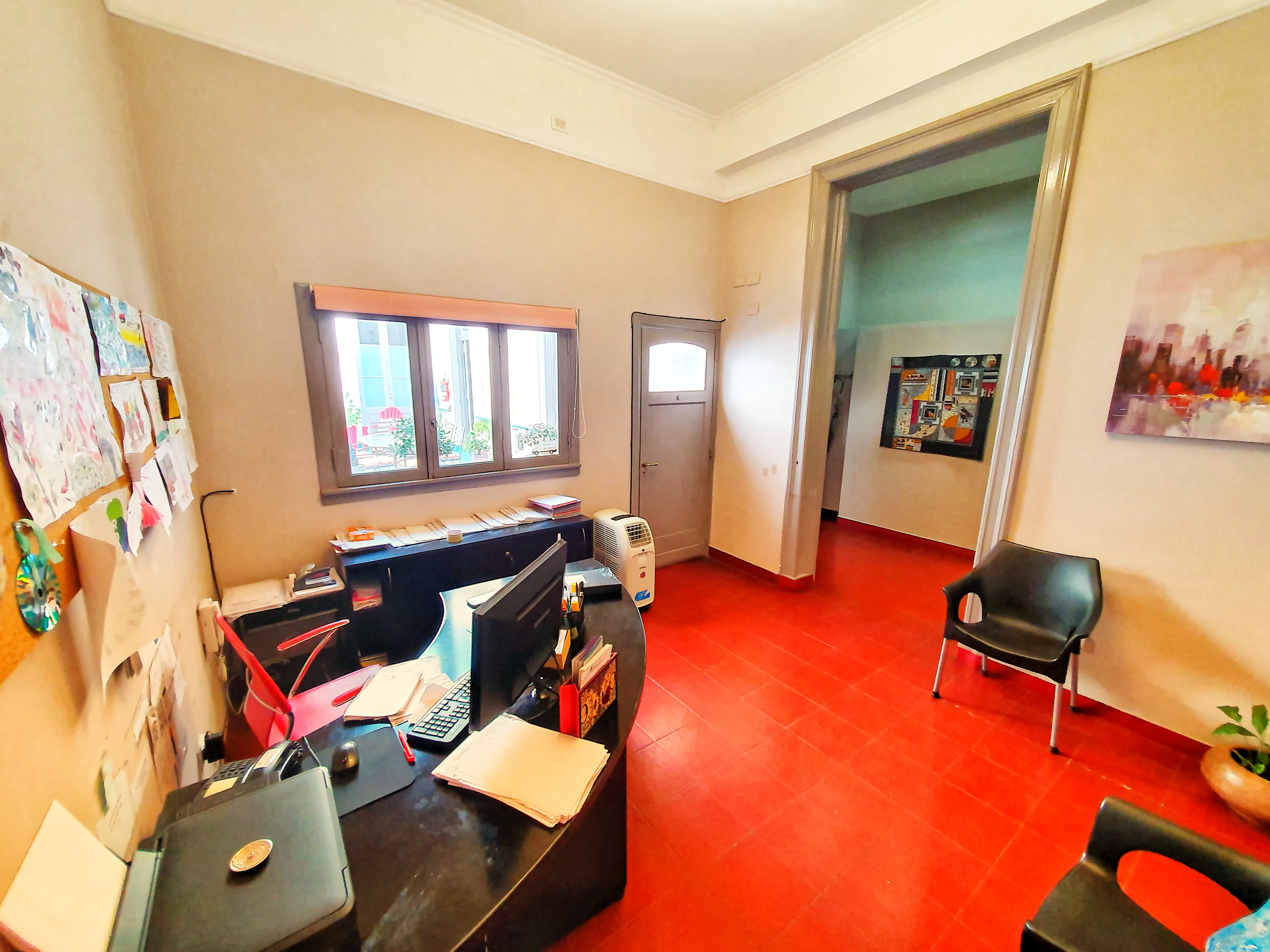 Oficina de recepción con escritorio y dibujos de los concurrentes en la pared
