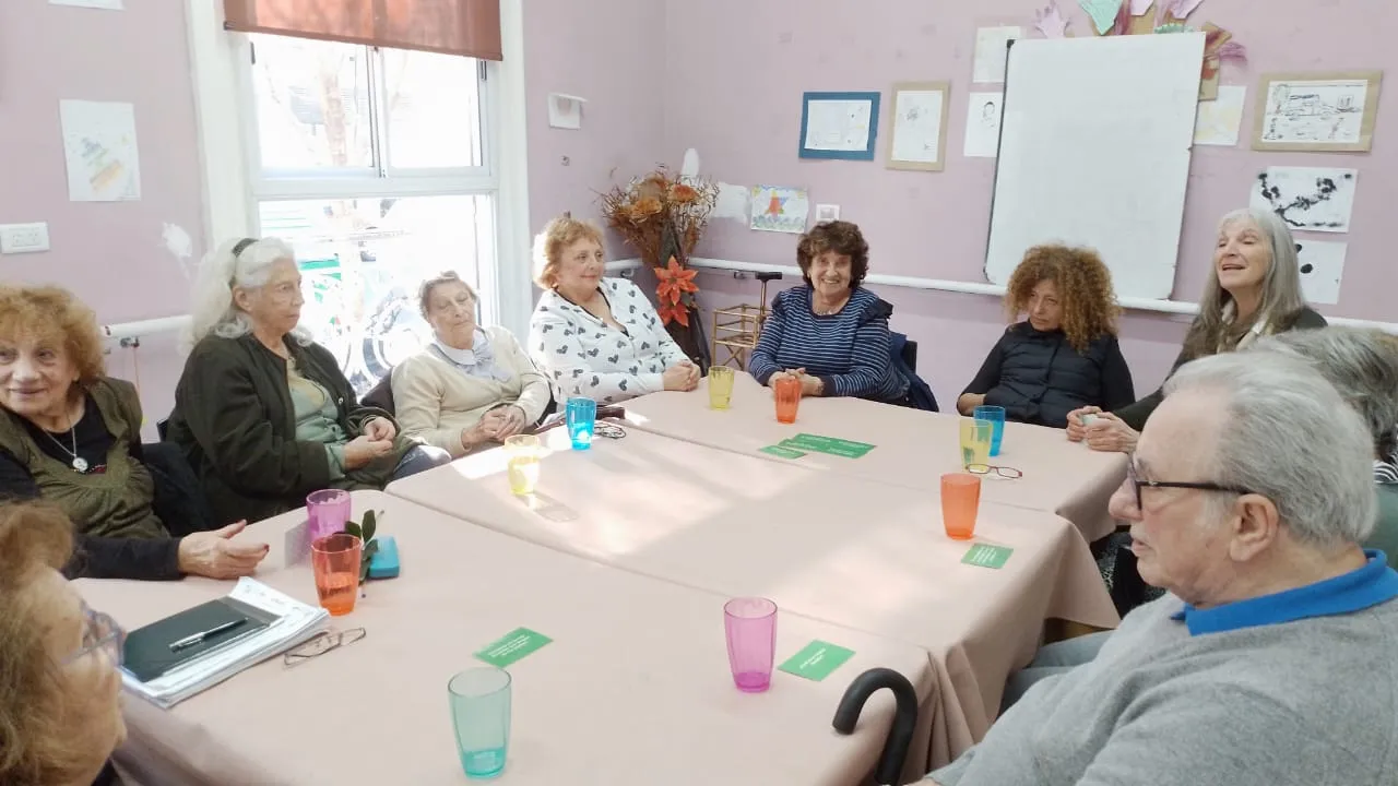 Concurrentes conversan en ronda alrededor de una mesa durante una dinámica grupal
